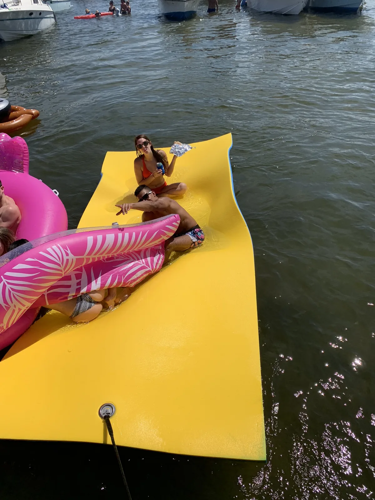 Bachelorette party relaxing on the lily-pad float beside the Breezy Tiki boat
