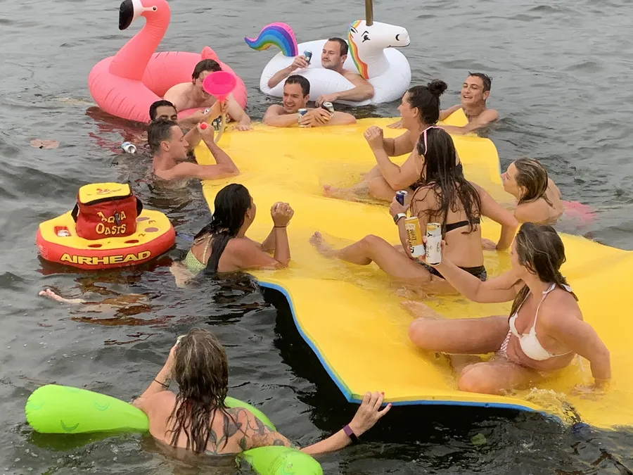 Group enjoying drinks at the sandbar on a Breezy Tiki charter