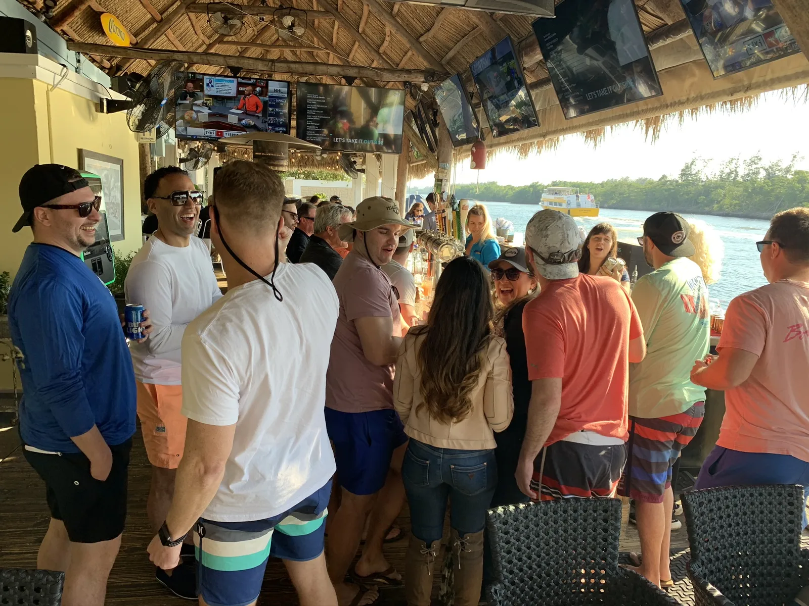Corporate team gathered under the tiki bar canopy aboard Breezy Tiki